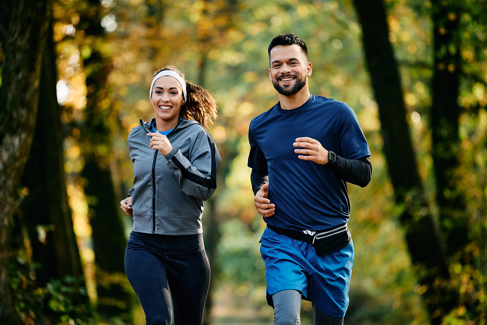 Happy athletic couple jogging during autumn day in the park.; Shutterstock ID 2389365915; other: -; purchase_order: -; client: -; job: -